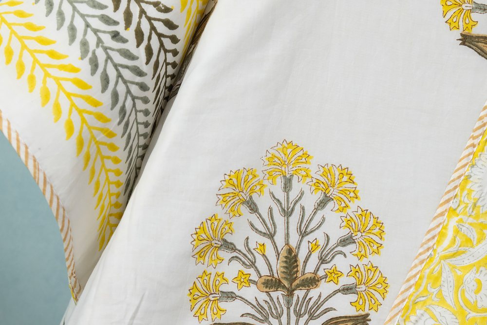 Close up of a Sanganer style floral posy hand block print on a pale cotton ground